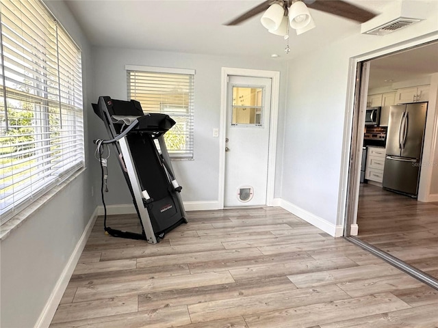 exercise room with light wood-type flooring and ceiling fan