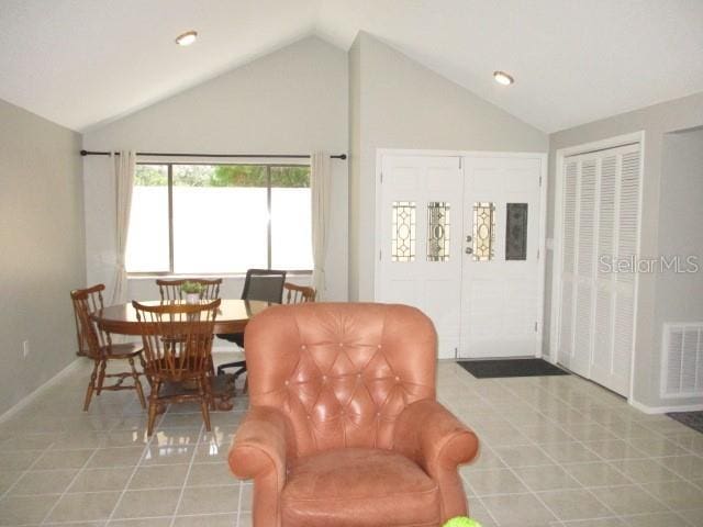 interior space with vaulted ceiling and light tile patterned floors