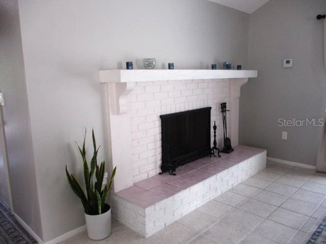 details with a brick fireplace and tile patterned floors