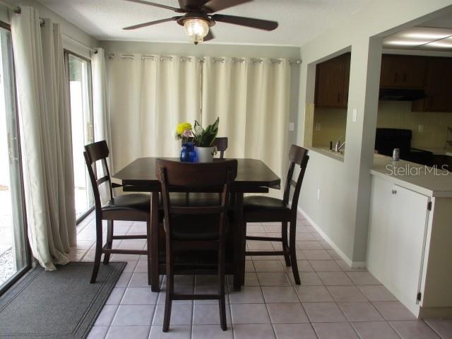 dining room with ceiling fan and light tile patterned floors