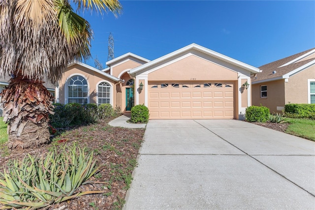 single story home with stucco siding, driveway, and a garage