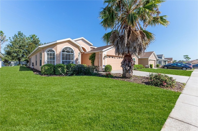 ranch-style house featuring driveway, stucco siding, a front yard, and a garage