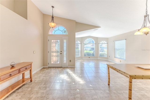 entryway featuring baseboards, lofted ceiling, and light tile patterned floors
