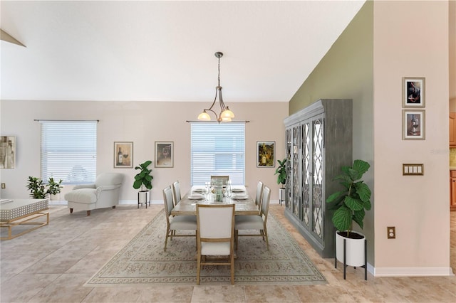 dining area featuring high vaulted ceiling, a healthy amount of sunlight, light tile patterned floors, and an inviting chandelier