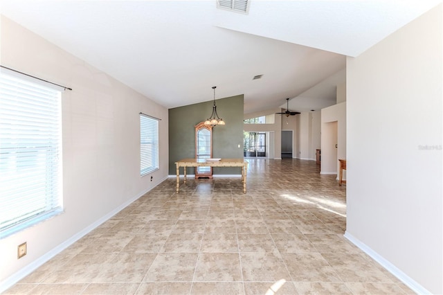 unfurnished dining area featuring vaulted ceiling, light tile patterned floors, ceiling fan with notable chandelier, baseboards, and visible vents