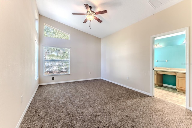 empty room with visible vents, baseboards, ceiling fan, lofted ceiling, and light colored carpet