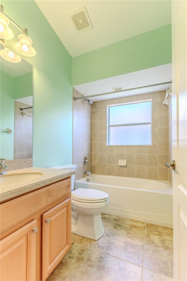 full bathroom featuring tiled shower / bath combo, tile patterned floors, toilet, and vanity