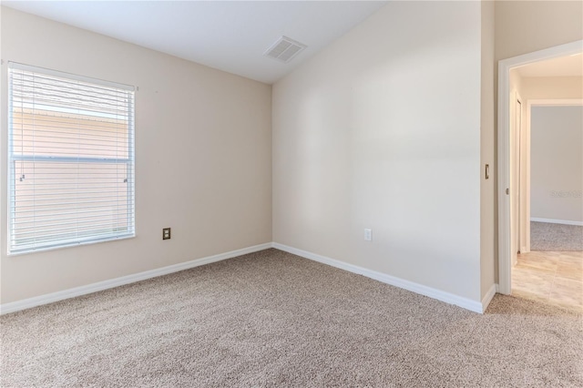 carpeted spare room with baseboards and visible vents