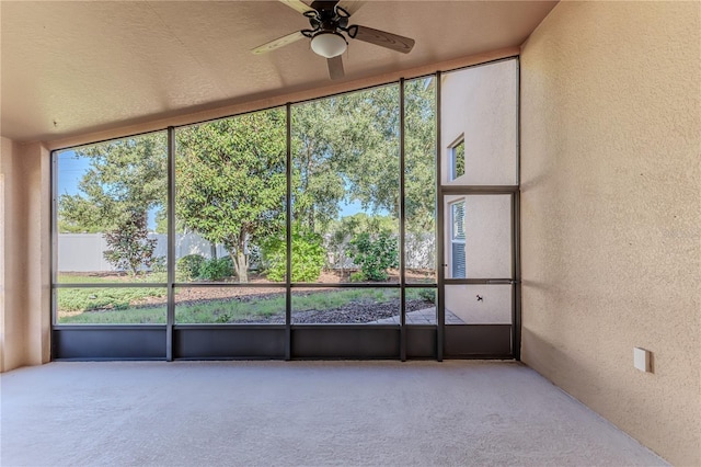 unfurnished sunroom featuring a ceiling fan