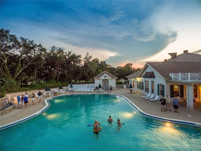 pool featuring an outbuilding, fence, and a patio area