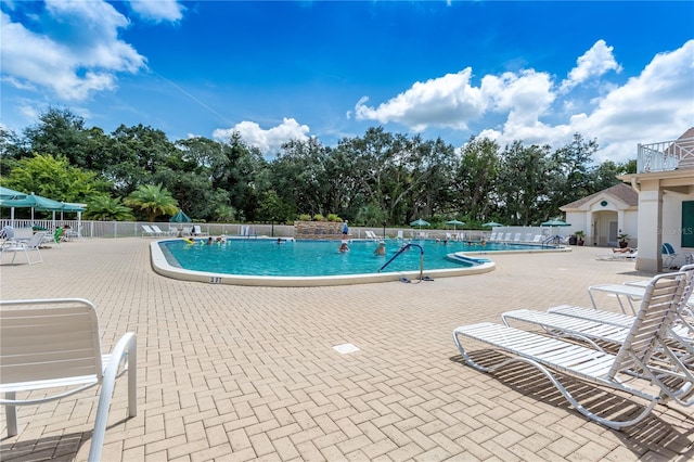 community pool featuring fence and a patio area