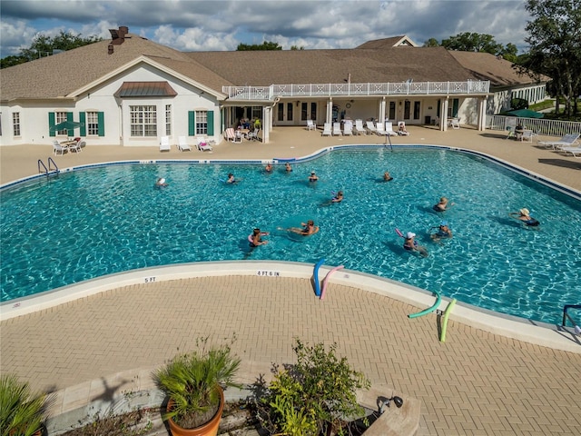 community pool featuring french doors, fence, and a patio area