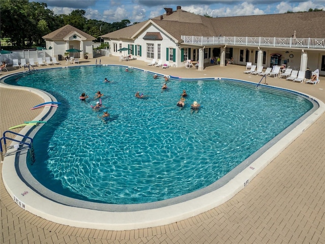 community pool featuring a patio and fence
