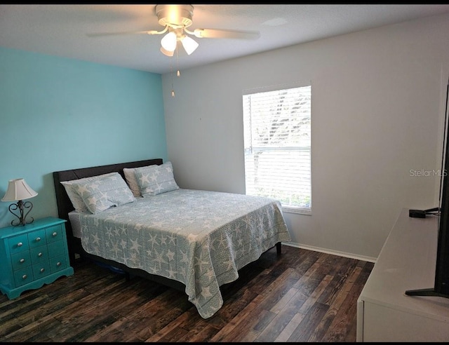 bedroom featuring baseboards, wood finished floors, and a ceiling fan