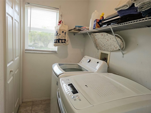 laundry area featuring tile patterned floors, laundry area, washing machine and dryer, and baseboards