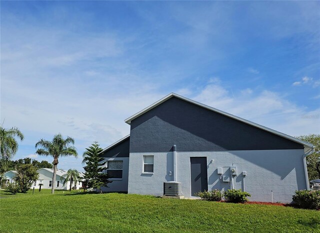 back of property with a lawn and central air condition unit