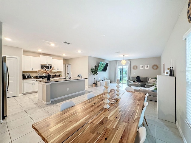 dining space with light tile patterned floors and sink