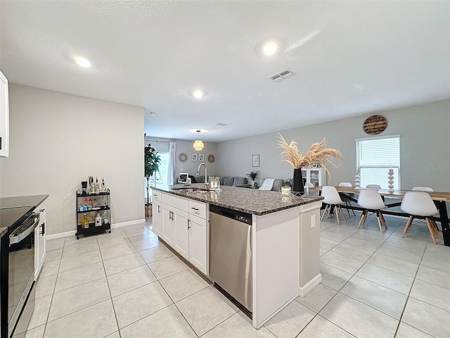 kitchen with white cabinets, dark stone countertops, stainless steel appliances, sink, and a textured ceiling