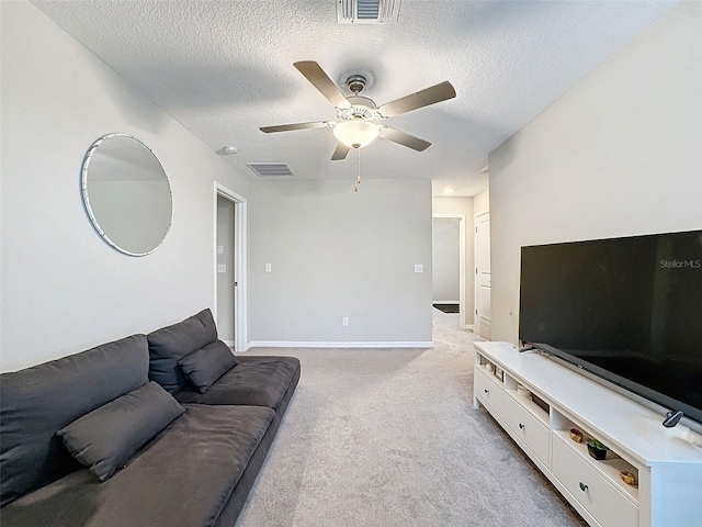 carpeted living room featuring ceiling fan and a textured ceiling