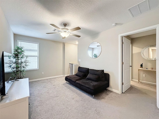 sitting room featuring ceiling fan, carpet, and a textured ceiling