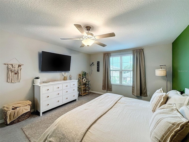 bedroom with ceiling fan, a textured ceiling, and carpet floors