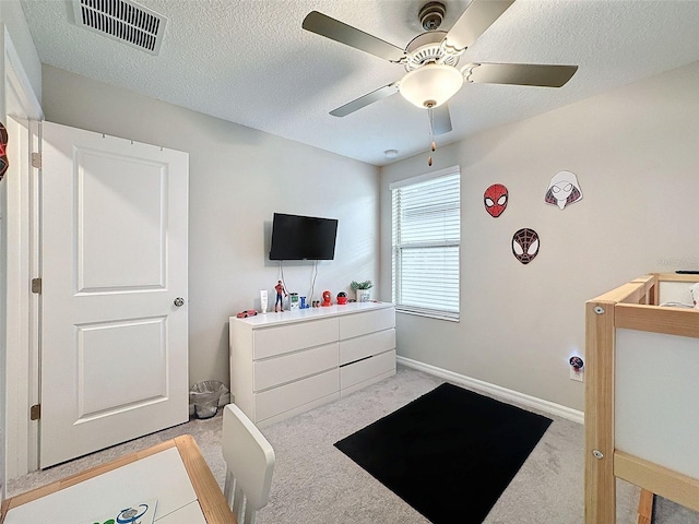 bedroom featuring light colored carpet, ceiling fan, and a textured ceiling