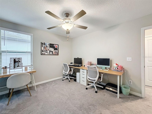 carpeted office with a textured ceiling and ceiling fan