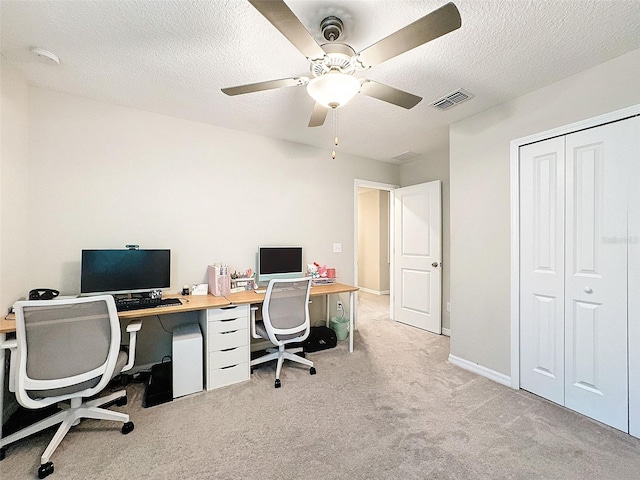 carpeted office featuring a textured ceiling and ceiling fan