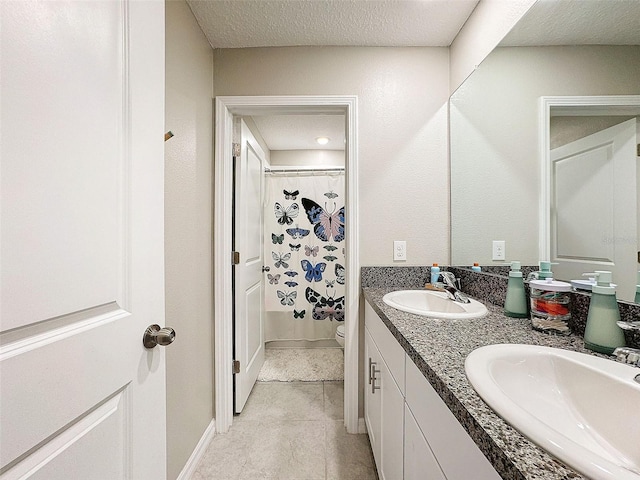 bathroom featuring curtained shower, tile patterned flooring, toilet, vanity, and a textured ceiling