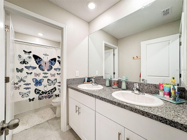 bathroom with a shower with shower curtain, tile patterned flooring, toilet, vanity, and a textured ceiling