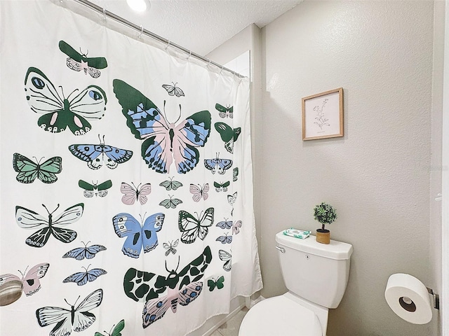 bathroom with toilet, a shower with curtain, and a textured ceiling