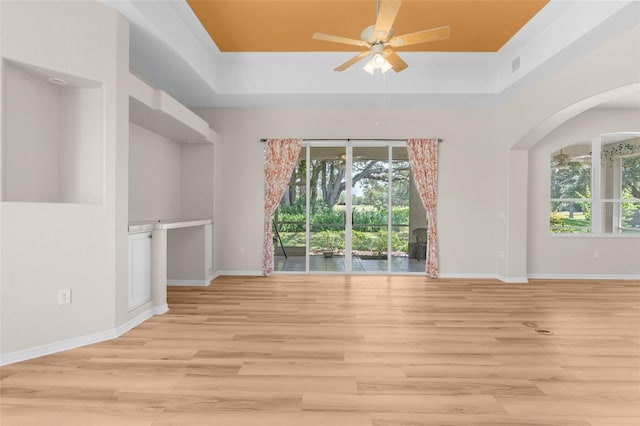 interior space featuring crown molding, light hardwood / wood-style flooring, a tray ceiling, and ceiling fan