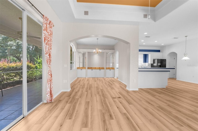 unfurnished living room featuring light wood-type flooring and an inviting chandelier