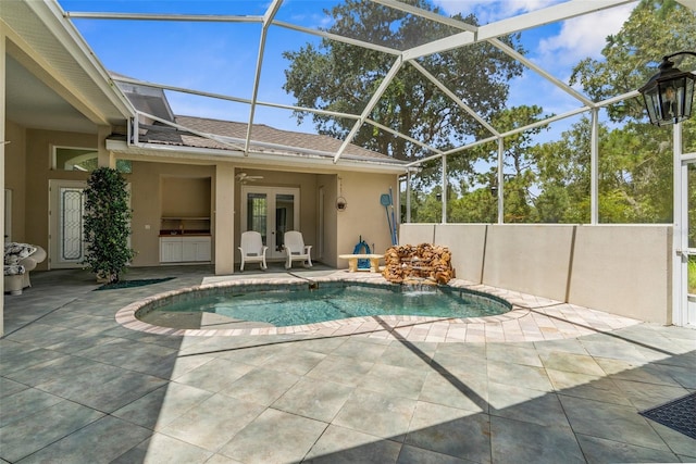 view of pool featuring pool water feature, ceiling fan, a lanai, and a patio