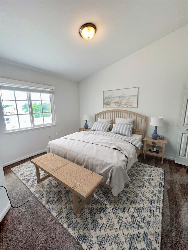 bedroom with lofted ceiling and dark carpet