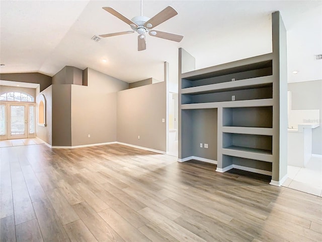 additional living space with baseboards, lofted ceiling, ceiling fan, wood finished floors, and built in shelves