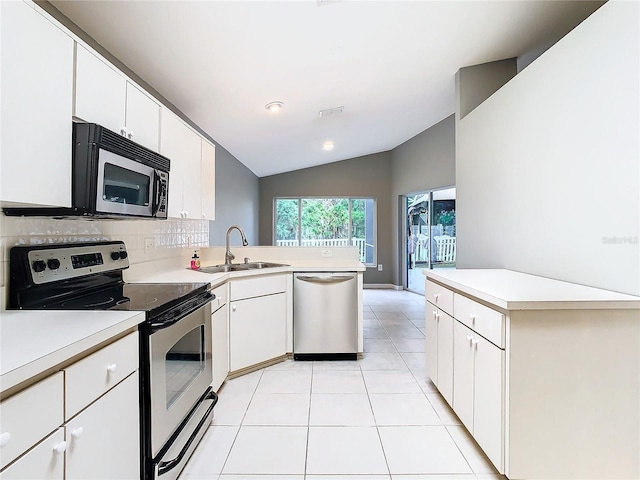 kitchen with a peninsula, stainless steel appliances, light countertops, a sink, and light tile patterned flooring