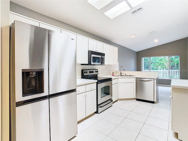 kitchen with a peninsula, a sink, visible vents, light countertops, and appliances with stainless steel finishes