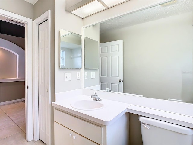 bathroom featuring toilet, tile patterned flooring, and vanity