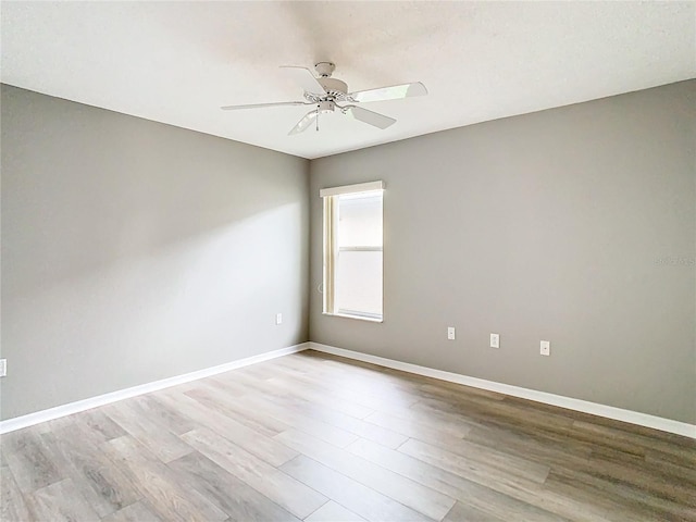 unfurnished room with ceiling fan, baseboards, and wood finished floors