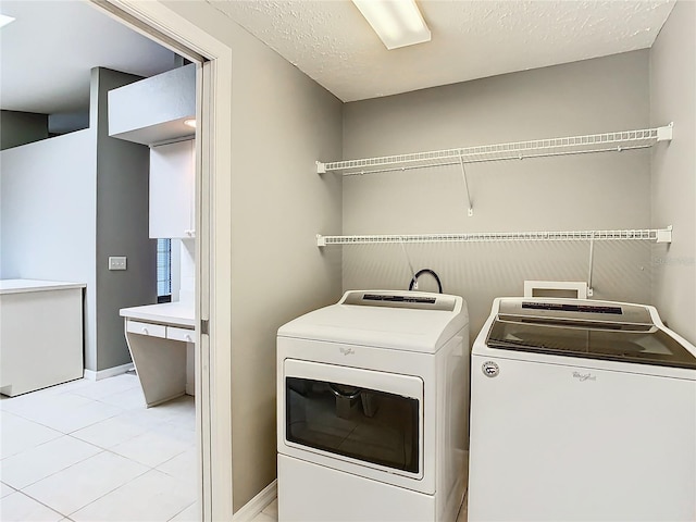 laundry area with a textured ceiling, laundry area, separate washer and dryer, and baseboards