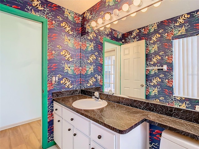 bathroom with vanity, hardwood / wood-style floors, and toilet