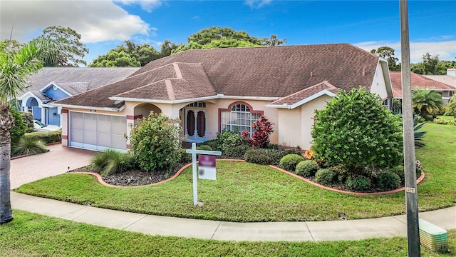 single story home featuring a garage and a front lawn