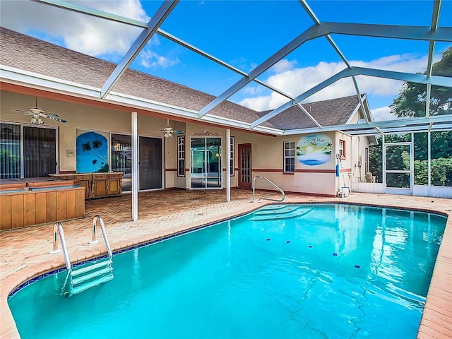 view of swimming pool with a bar, ceiling fan, a lanai, and a patio area