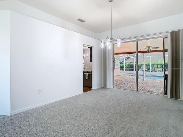 carpeted empty room with a sunroom, baseboards, and visible vents