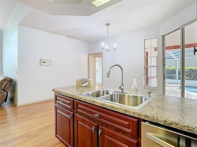 kitchen featuring reddish brown cabinets, dishwasher, a textured ceiling, light wood-type flooring, and a sink