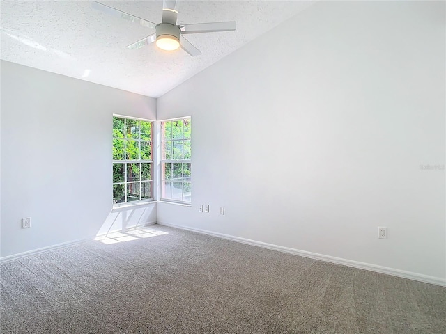 carpeted spare room with a textured ceiling, vaulted ceiling, a ceiling fan, and baseboards