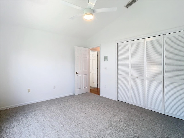 unfurnished bedroom with a closet, visible vents, a ceiling fan, carpet flooring, and vaulted ceiling