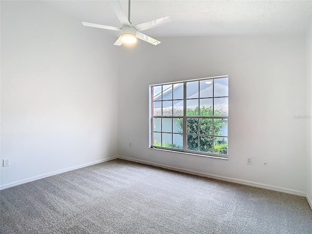 carpeted spare room featuring lofted ceiling, a ceiling fan, and baseboards