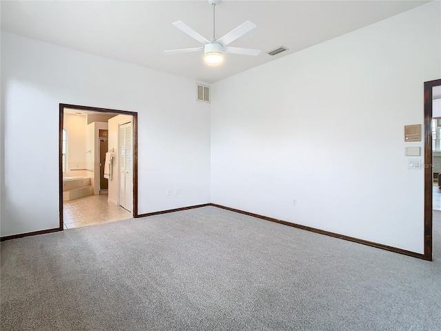 carpeted spare room with baseboards, visible vents, and a ceiling fan